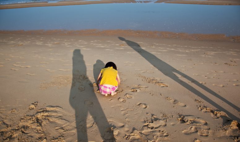 Little,Hurt,Child,And,Parents,Shade,On,The,Beach